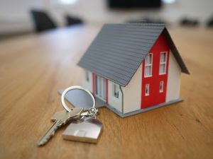 House key alongside small, model home